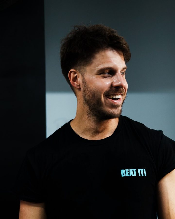 Francesco, a coach, smiling and looking to the side in the gym