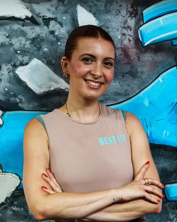 Oriana, a coach, smiling in front of the Beat It mural