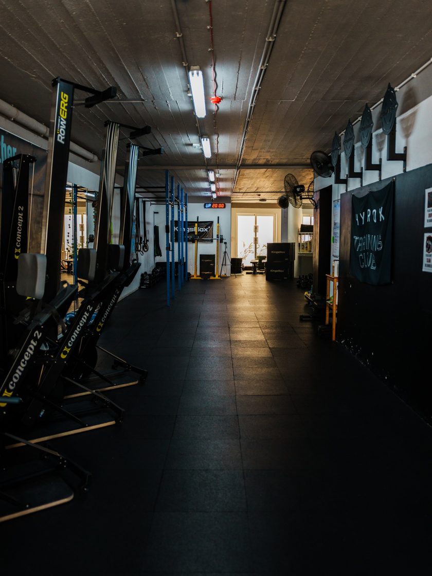 The top-floor gym down its length, ski ergs and rowers along one wall