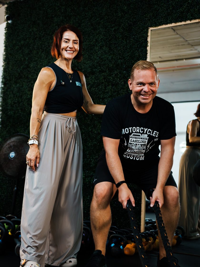 Diandra beside a member working with battle ropes in a personal training session